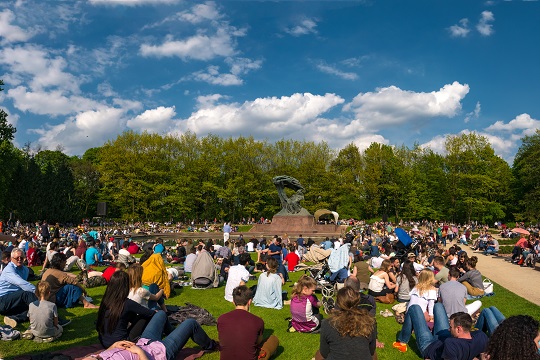 People seating on a grass enjoying Chopin's music