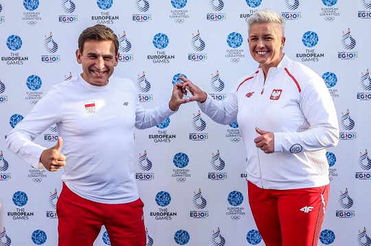 Two athletes posing inf front of EG23 wall