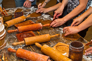 wooden table, rolling pins, hands making gingerbred dough
